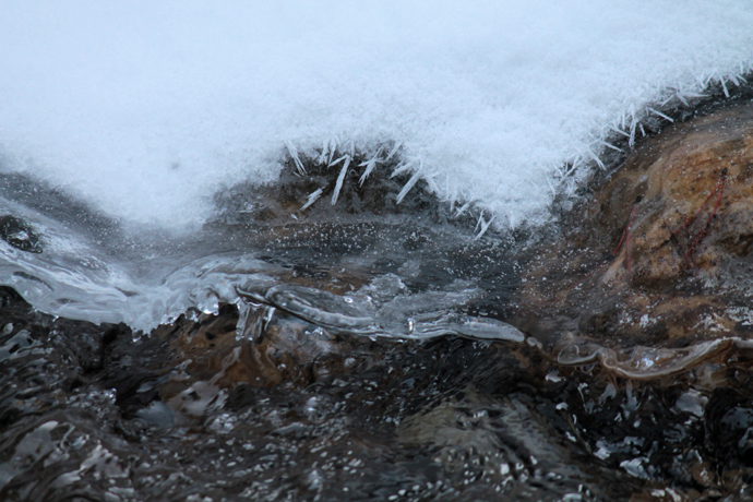 גדת הקיפאון בנחל לואיז. קרום קרח שקצותיו מוחלקים משמש כבסיס לשלג טרי. מתחת, מי קרח שועטים בעוז, מסרבים להשאר קפואים.